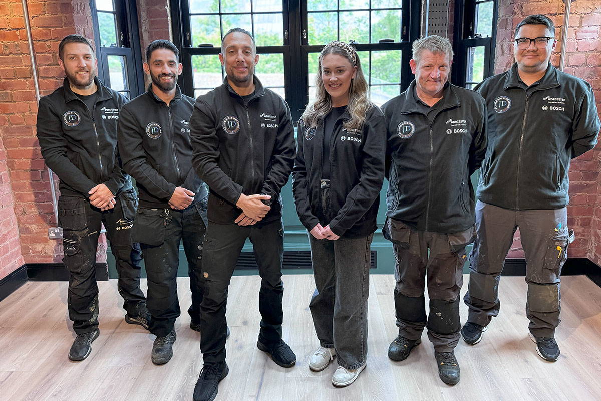 Team posing in work uniforms indoors.