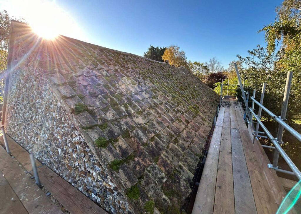 Mossy roof with scaffolding beside it