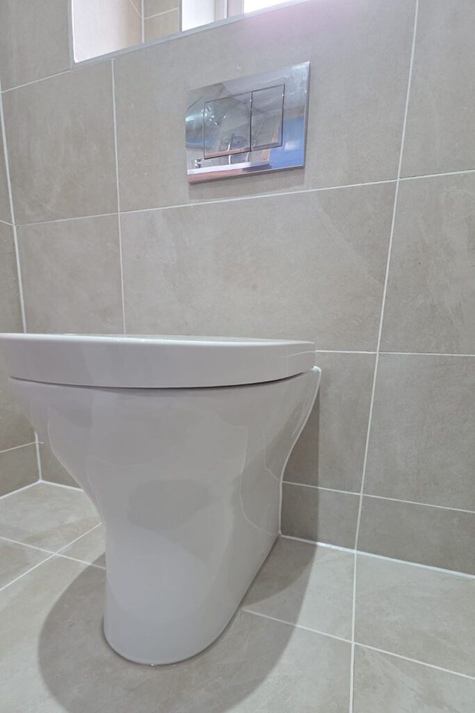 Modern toilet in tiled bathroom setting.