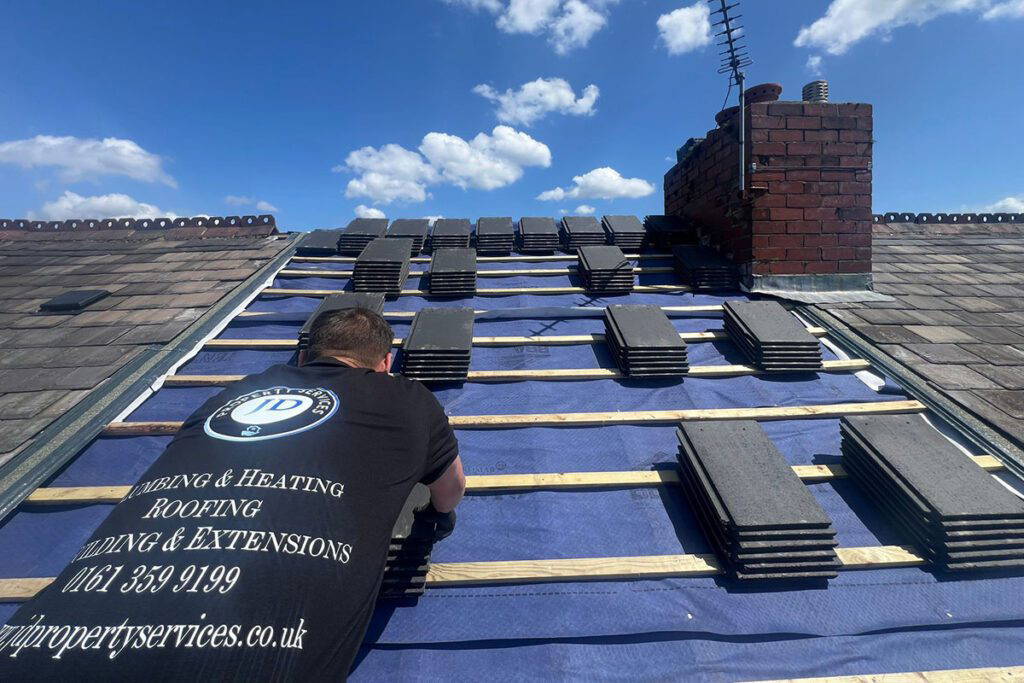 Man installing roof tiles on house