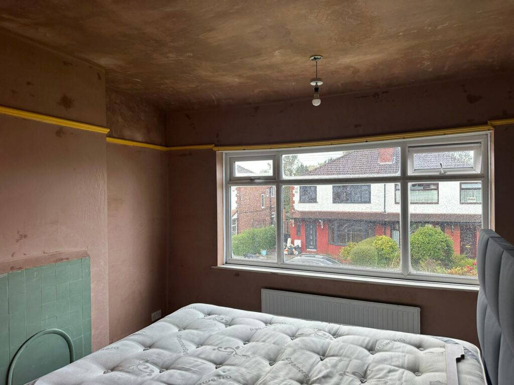 Unfinished room with a mattress and window